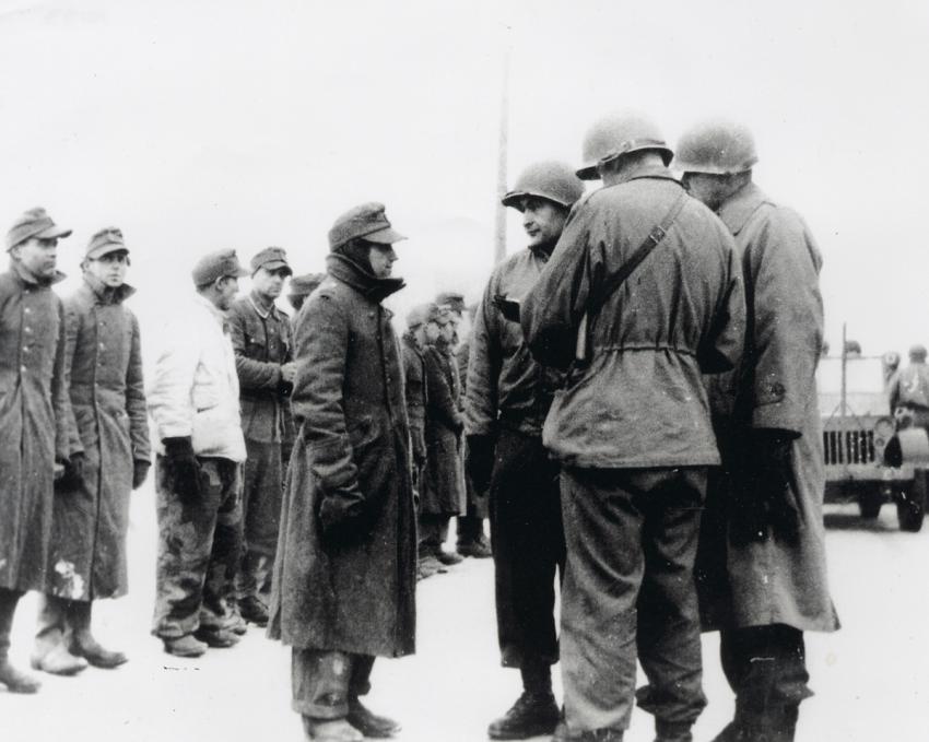 החייל האמריקאי רוברט ברנד (שלישי מימין) חוקר שבויים גרמנים 