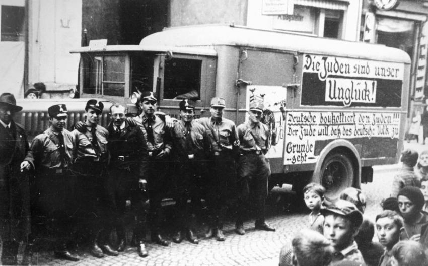 Würzburg on &quot;Boycott Day&quot;, 1 April 1933. SS and SA militiamen next to a truck bearing banners calling to boycott Jewish businesses. One of the banners reads &quot;The Jews are our Disaster&quot; (Die Juden sind unser Unglück).