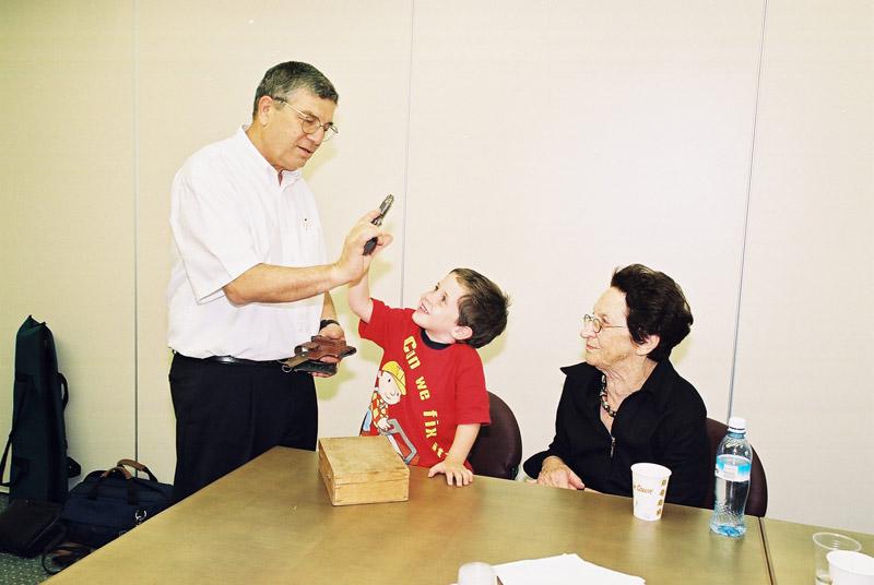 נועם דיסטהיים קובנר, הנכד בן ה-4, וויטקה קובנר מעניקים את אקדחו של אבא קובנר לאבנר שלו, יו&amp;quot;ר יד ושם
