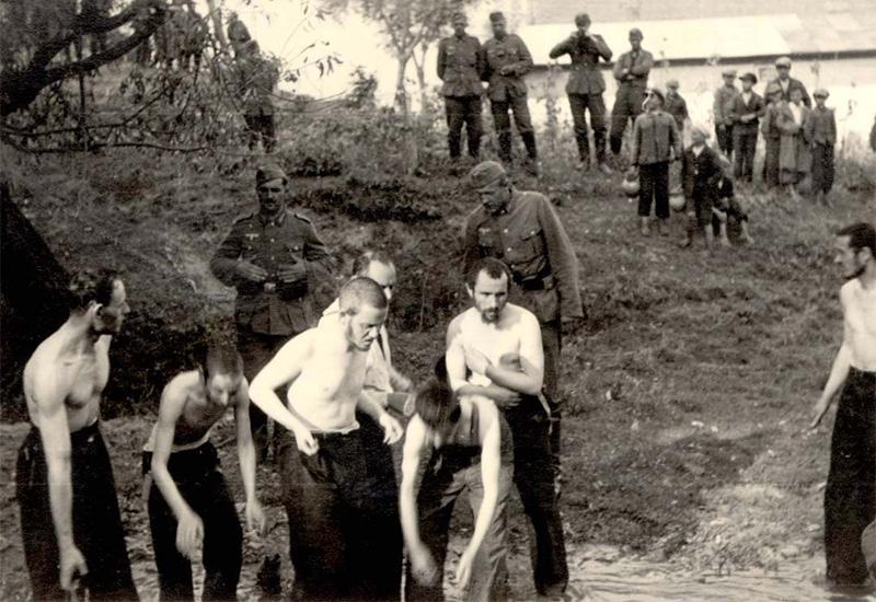 Poland ,Lubicza, חיילים גרמנים מאלצים יהודים להתפשט ולהתרחץ בנהר, בעוד חיילים אחרים ותושבים מקומיים צופים בהתעללות.