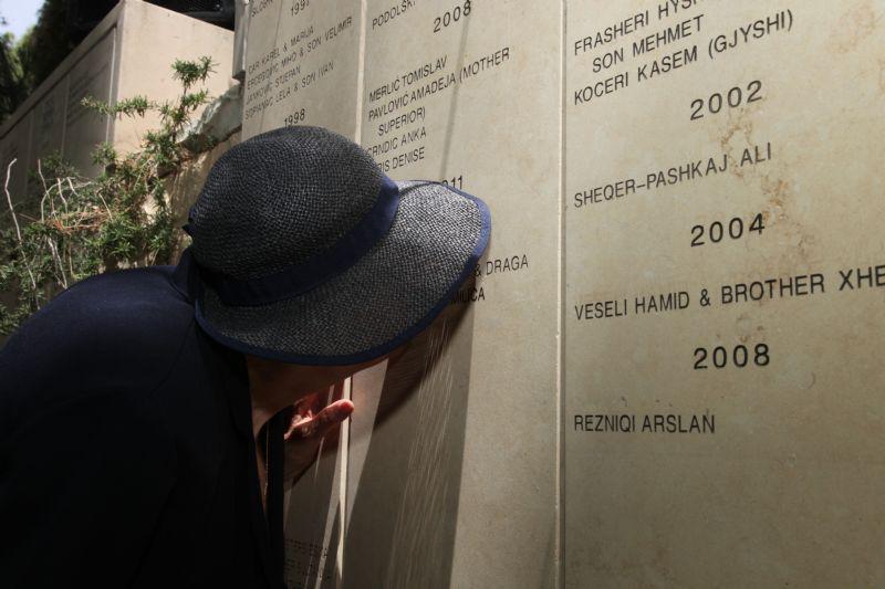 Vera Ugljesic, die von Zlatan Ugljesic gerettet wurde und ihn nach dem Krieg heiratete, küsst seinen Namen auf der Mauer im Garten der Gerechten, Mai 2013