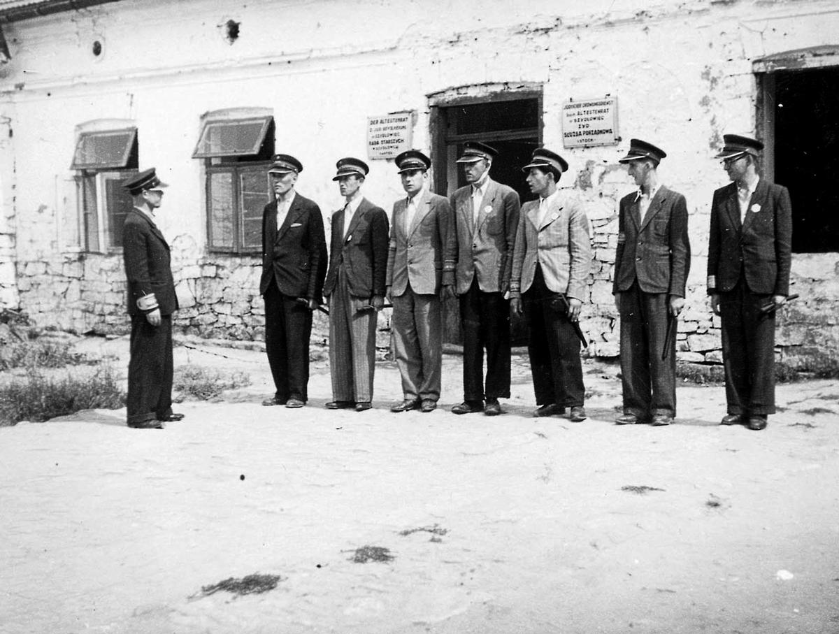 The Jewish Order Police in Szydłowiec at roll-call, standing in front of the offices of the Judenrat.