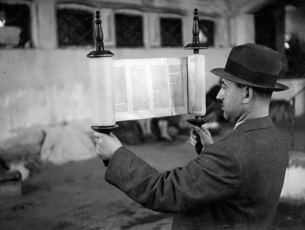Yerachmiel Morgenbesser, one of the Szydłowiec Judenrat members, holding a Torah scroll in synagogue in the ghetto.
