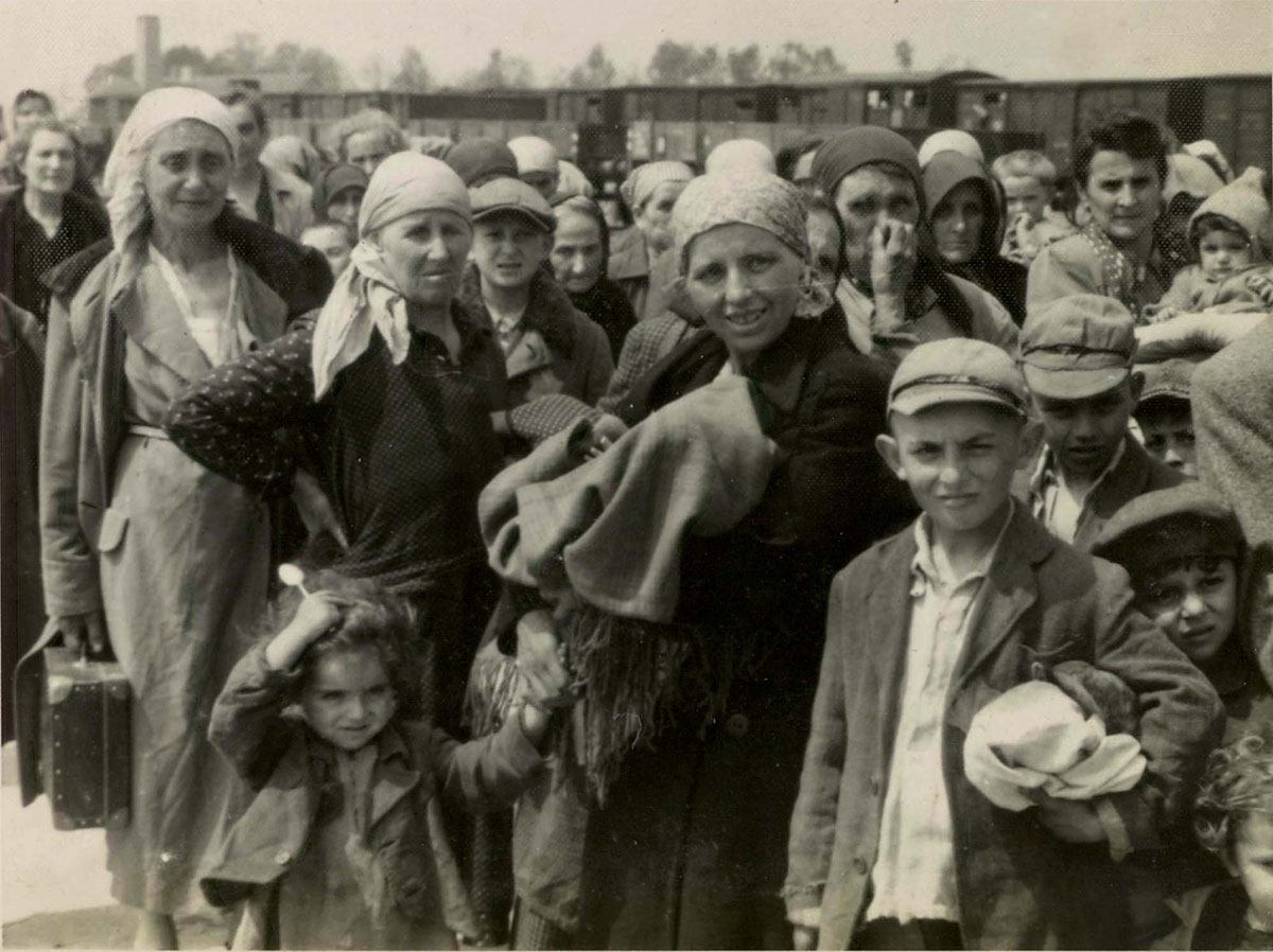 Женщины и дети на железнодорожной платформе Биркенау, известной как «рампа». Депортированные евреи проходили здесь селекцию: одних сразу же посылали на смерть, других отправляли на принудительные работы
