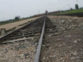 The train tracks in Auschwitz-Birkenau II. The entrance gate to the camp is in the background.